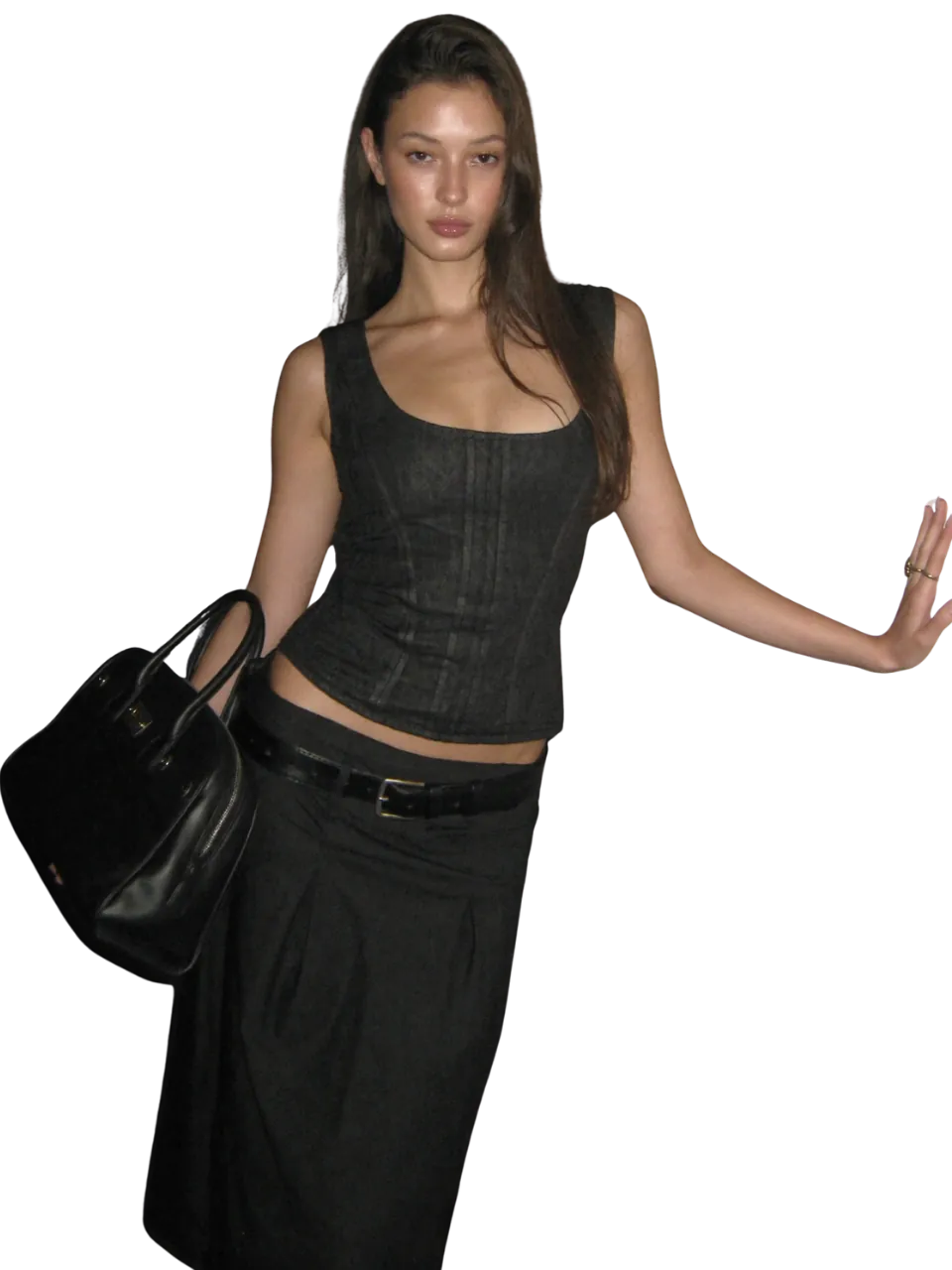 Model in a black corset top and long black skirt holding a leather tote