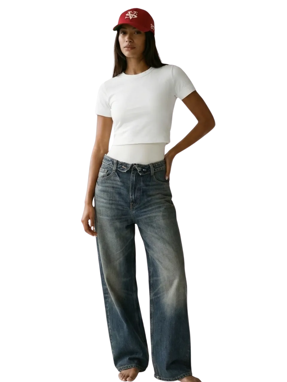 Model in a white tee, faded wide-leg jeans and a red cap